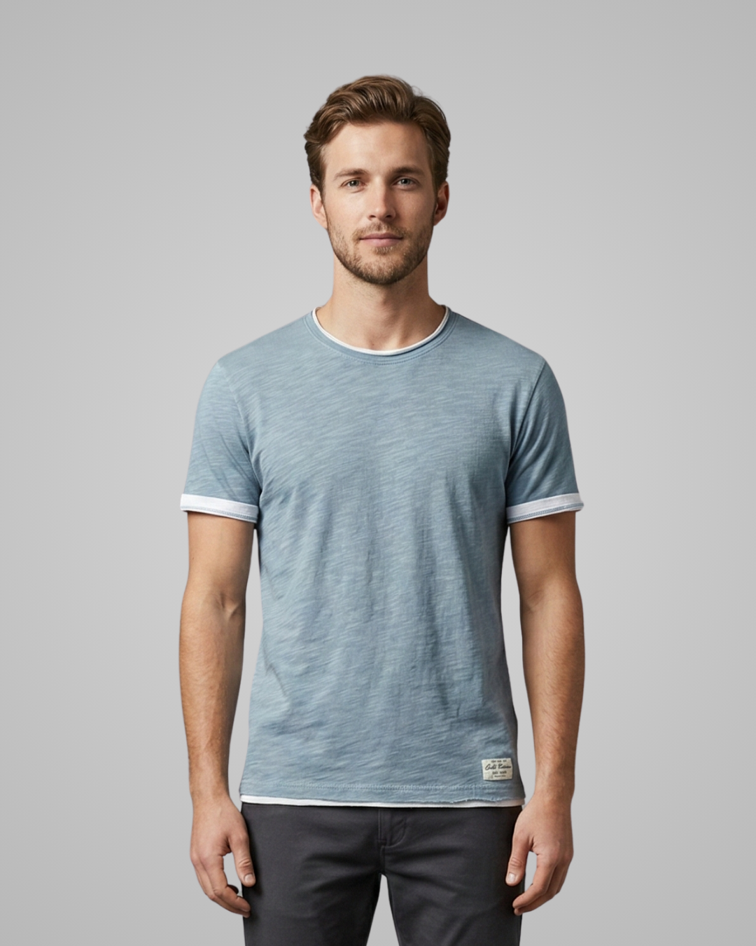 Man wearing a light blue striped t-shirt on a gray background