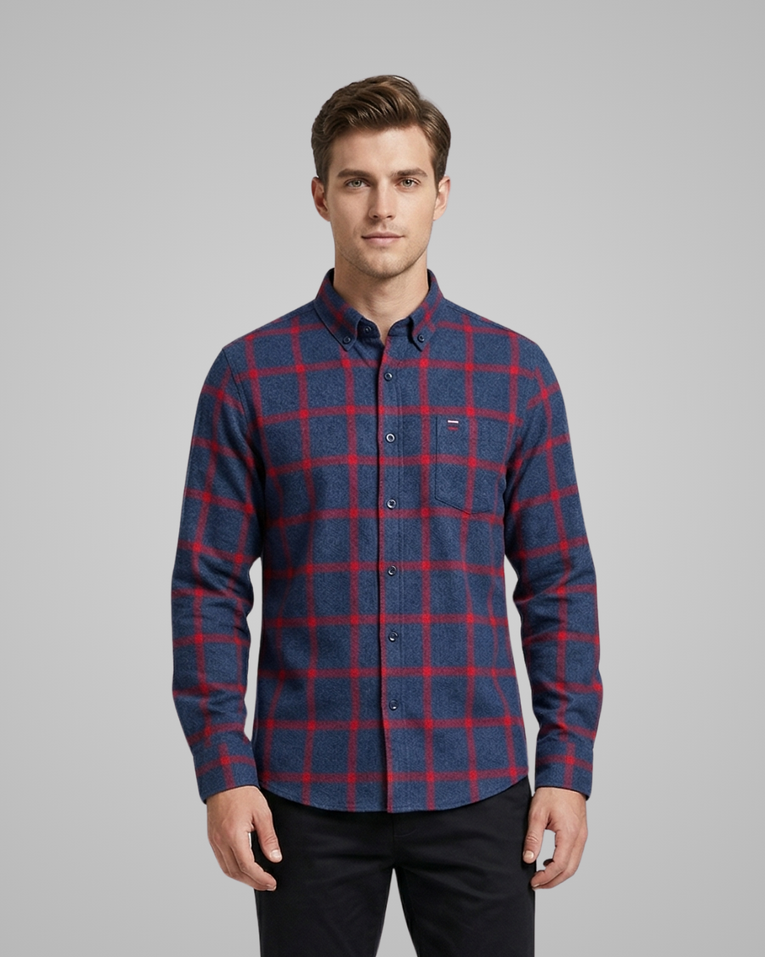 Man wearing a blue and red plaid shirt on a gray background