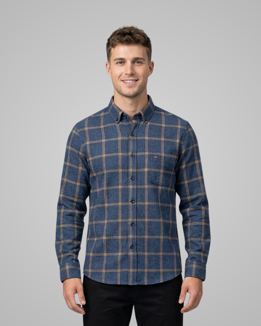Man wearing a blue plaid shirt against a gray background
