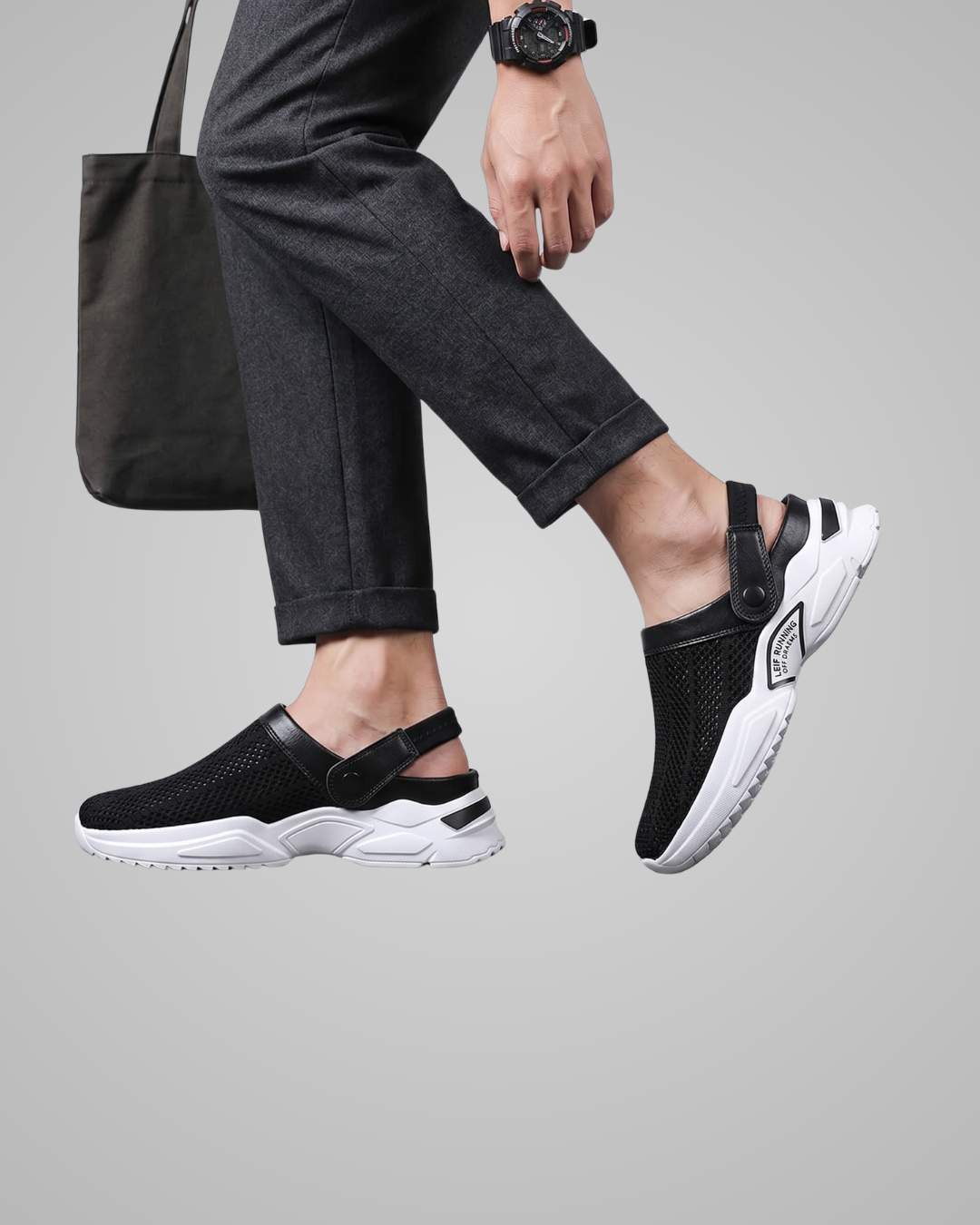 Person wearing black and white sandals on a gray background