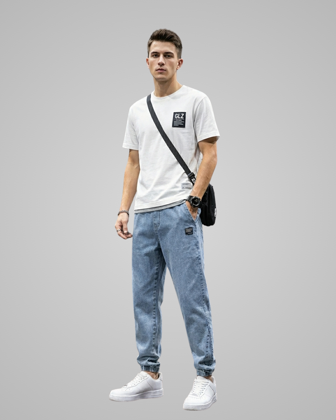 Man wearing a white t-shirt, light blue jeans, and white sneakers on a gray background