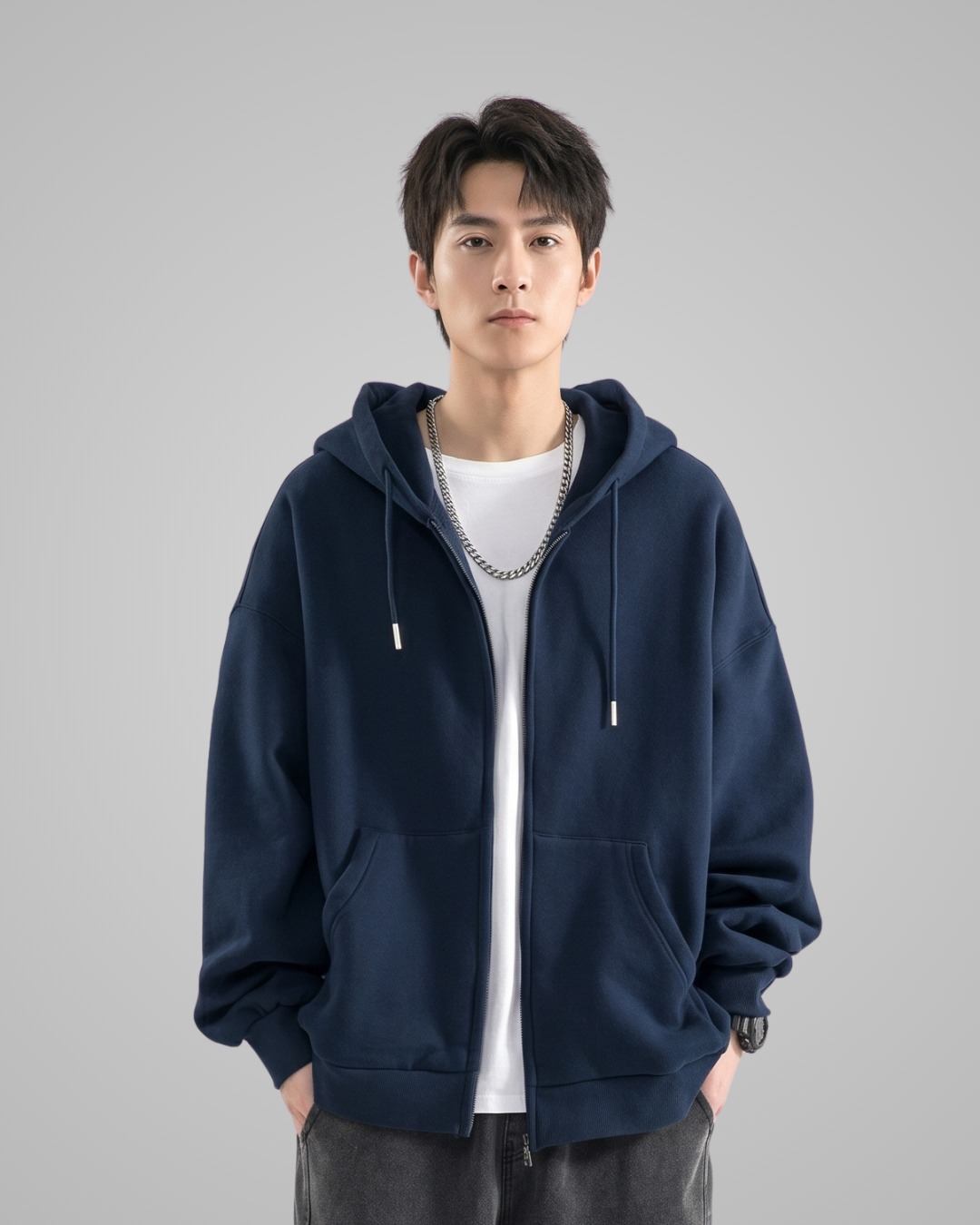 Person wearing a navy blue hoodie over a white shirt on a gray background