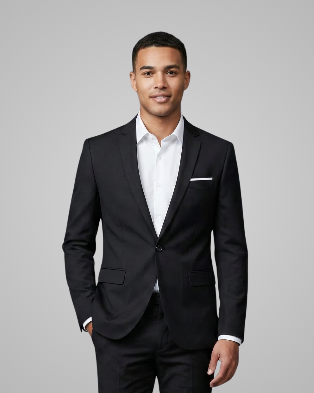 Man wearing a black suit and white shirt against a gray background