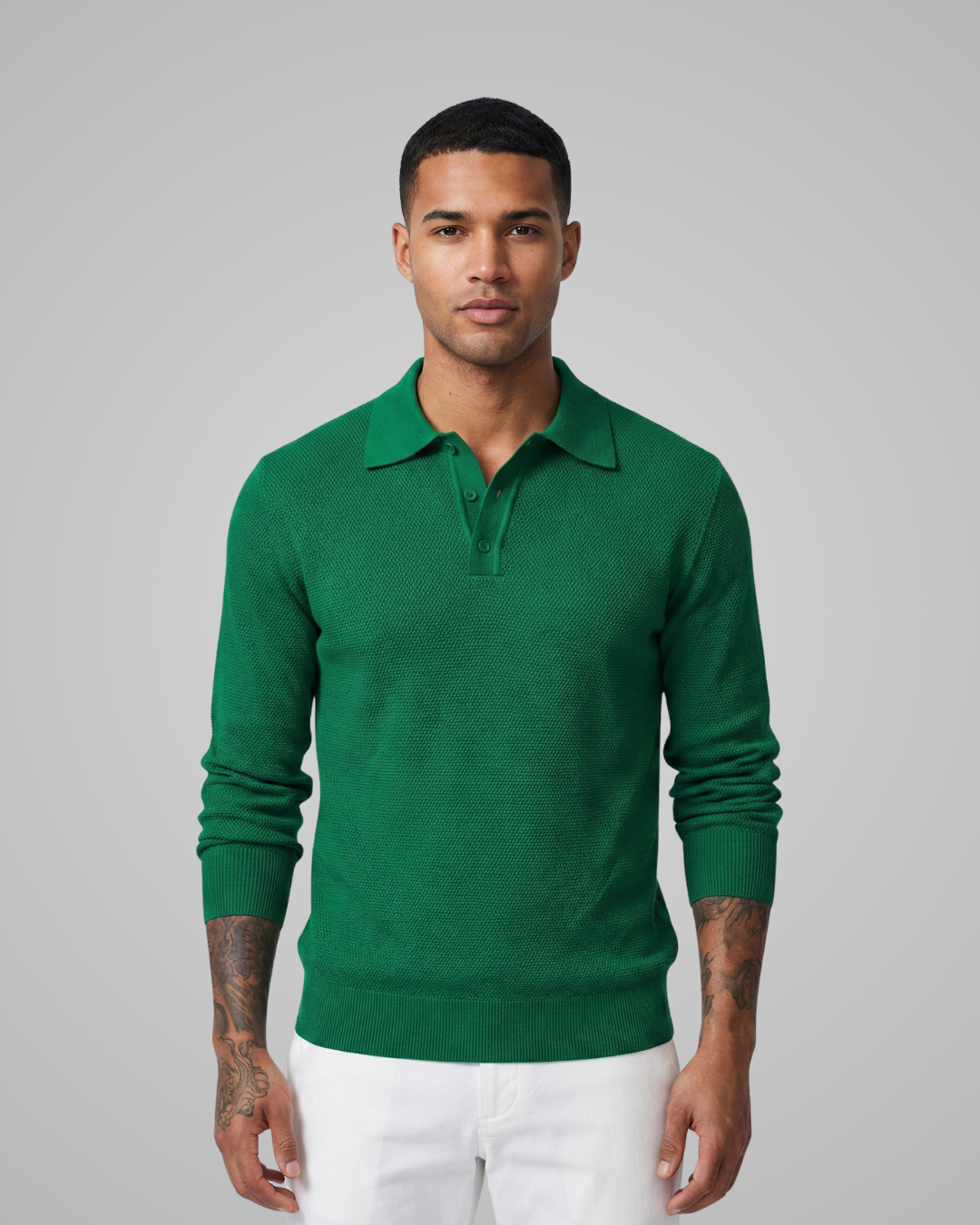 Man wearing a green long-sleeve polo shirt against a gray background