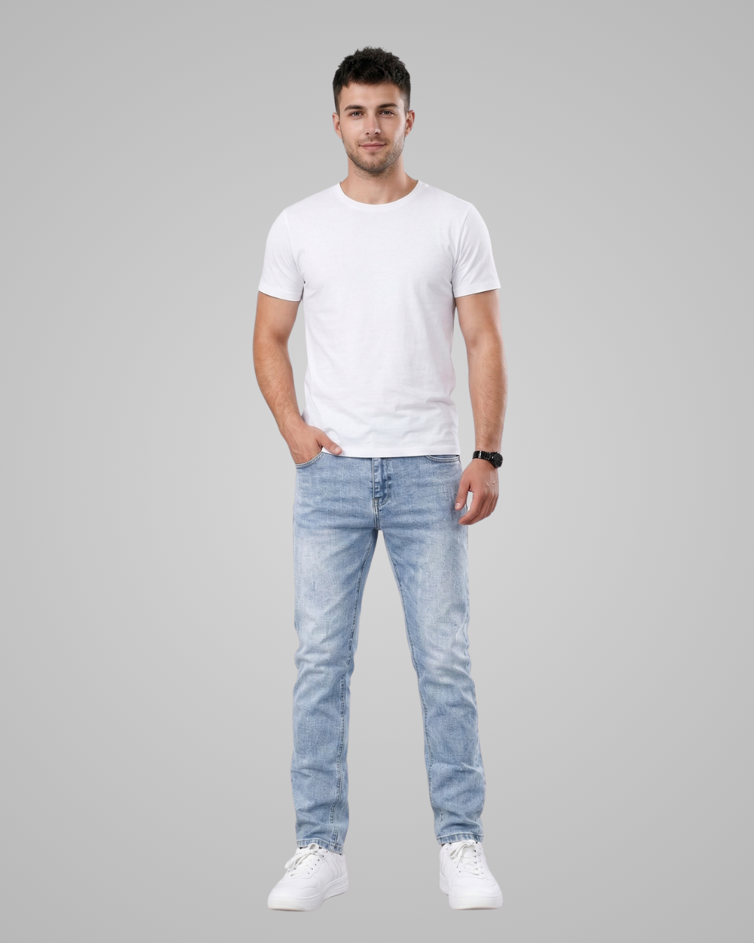 Man wearing a white t-shirt and light blue jeans on a gray background