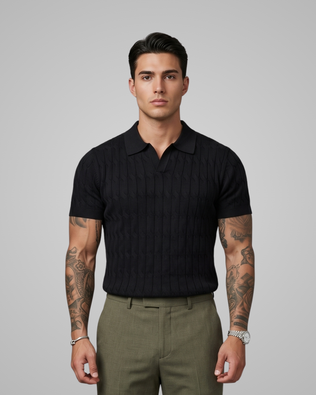 Man wearing a black polo shirt and green pants against a gray background
