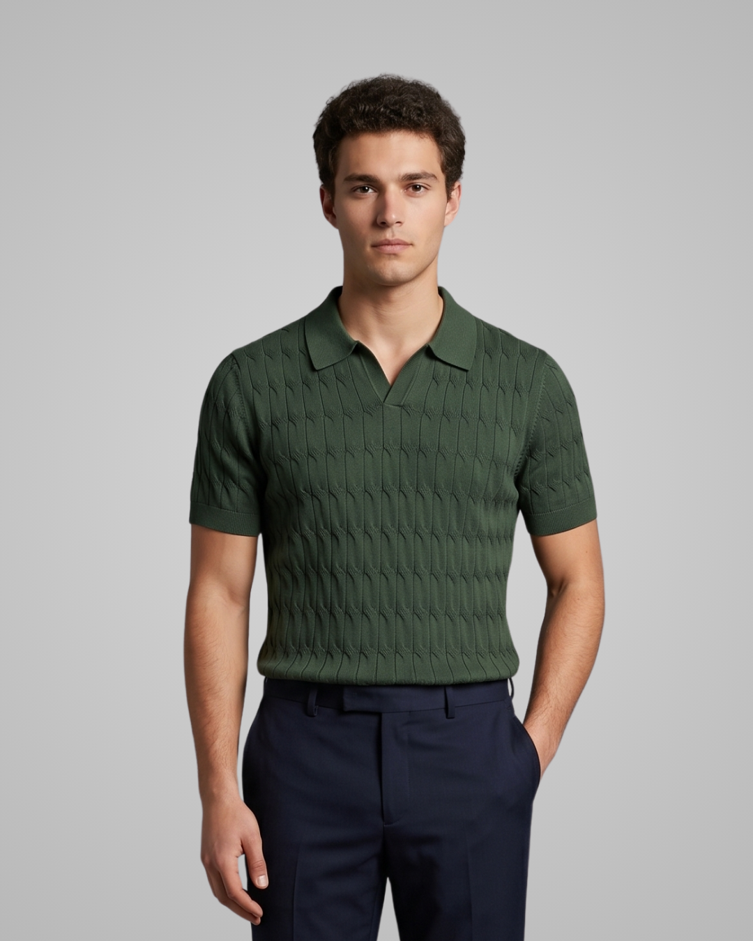 Man wearing a green textured polo shirt and dark pants on a gray background