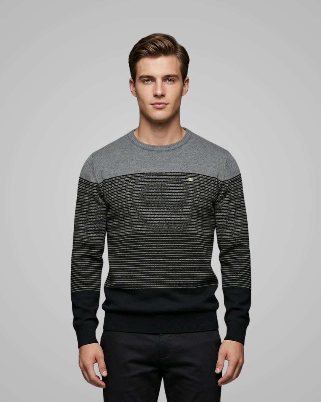 Man wearing a black and gray striped sweater on a gray background