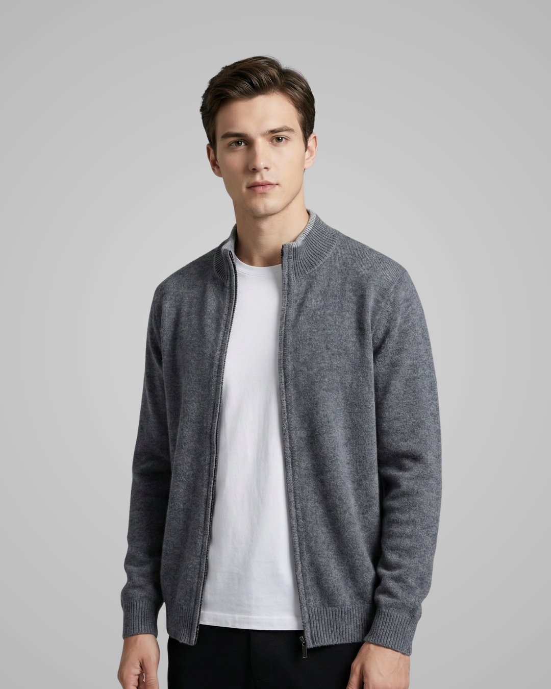 Man wearing a gray zip-up sweater over a white shirt on a gray background