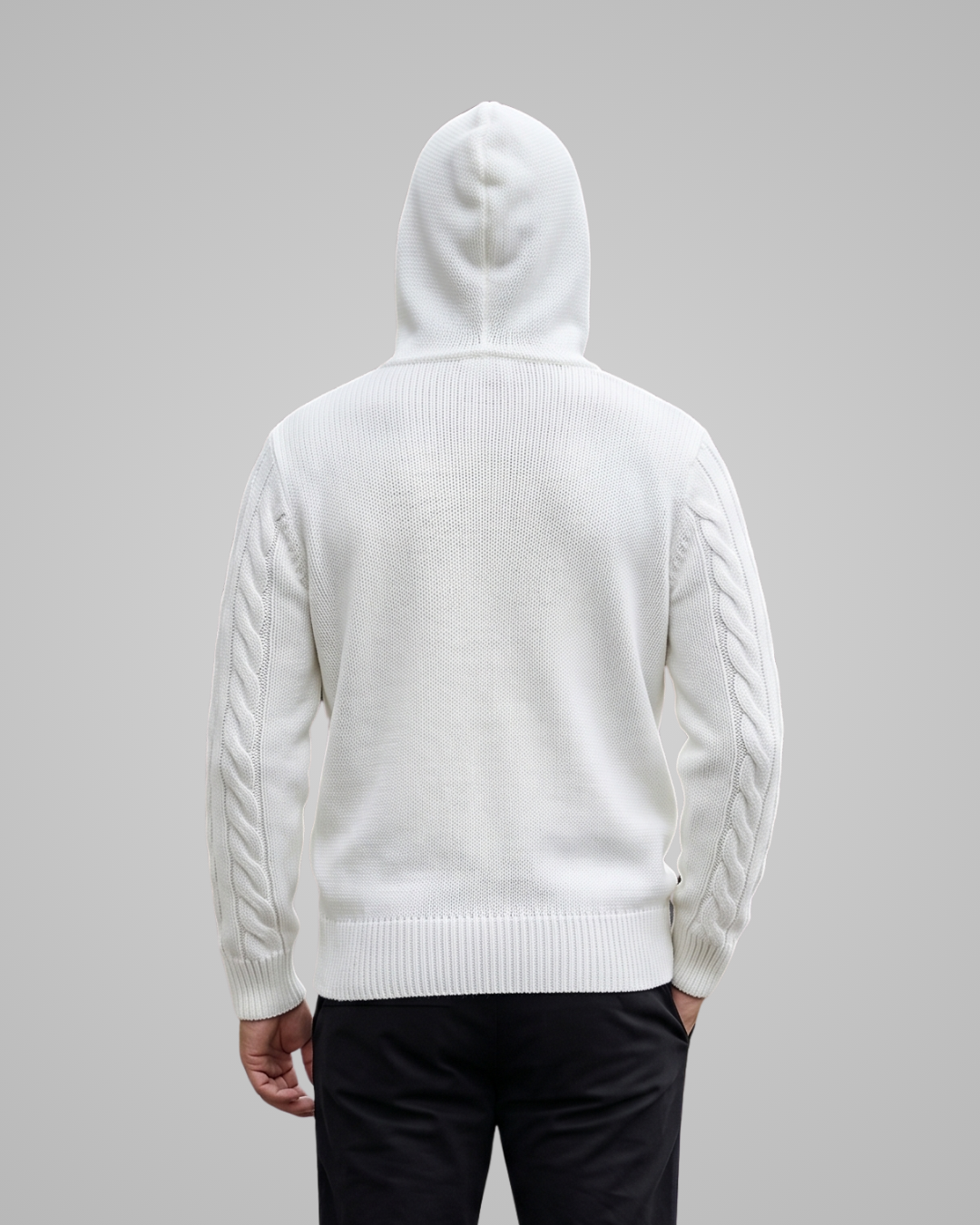 Person wearing a white hoodie with a subtle pattern on a gray background