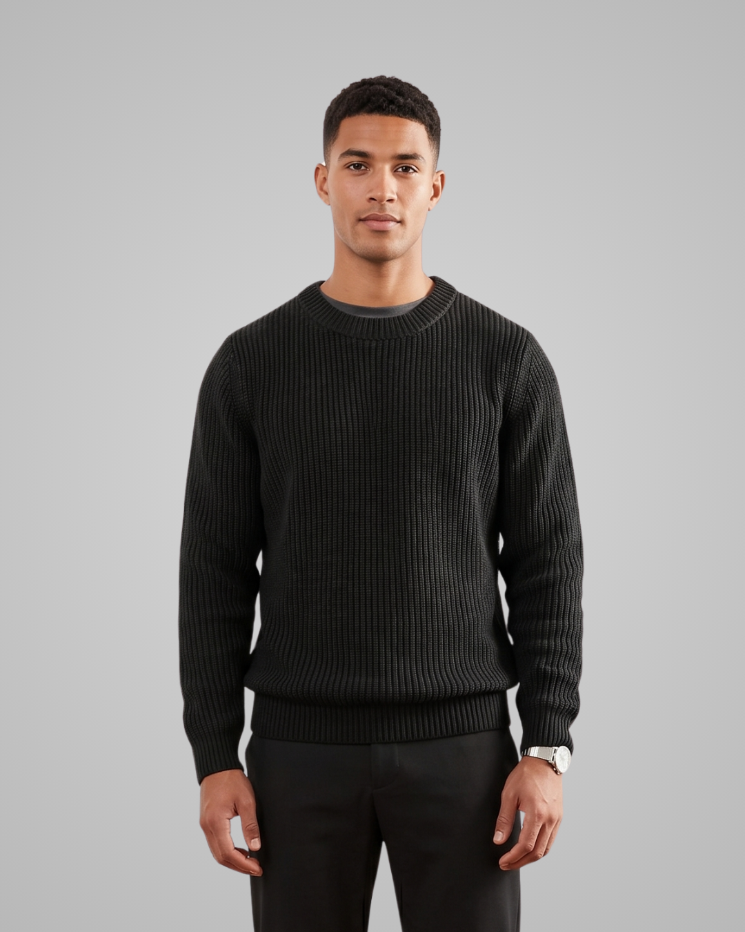 Man wearing a black sweater against a gray background