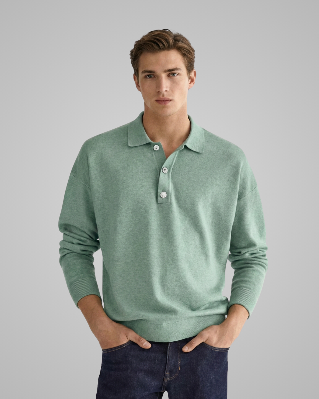 Man wearing a green long-sleeve polo shirt against a gray background