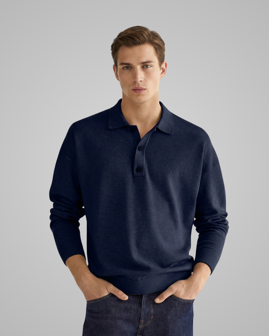 Man wearing a navy long-sleeve polo shirt against a gray background