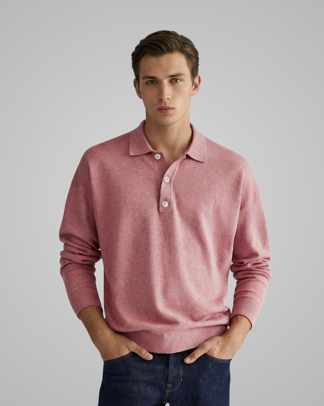 Man wearing a pink long-sleeve polo shirt against a gray background