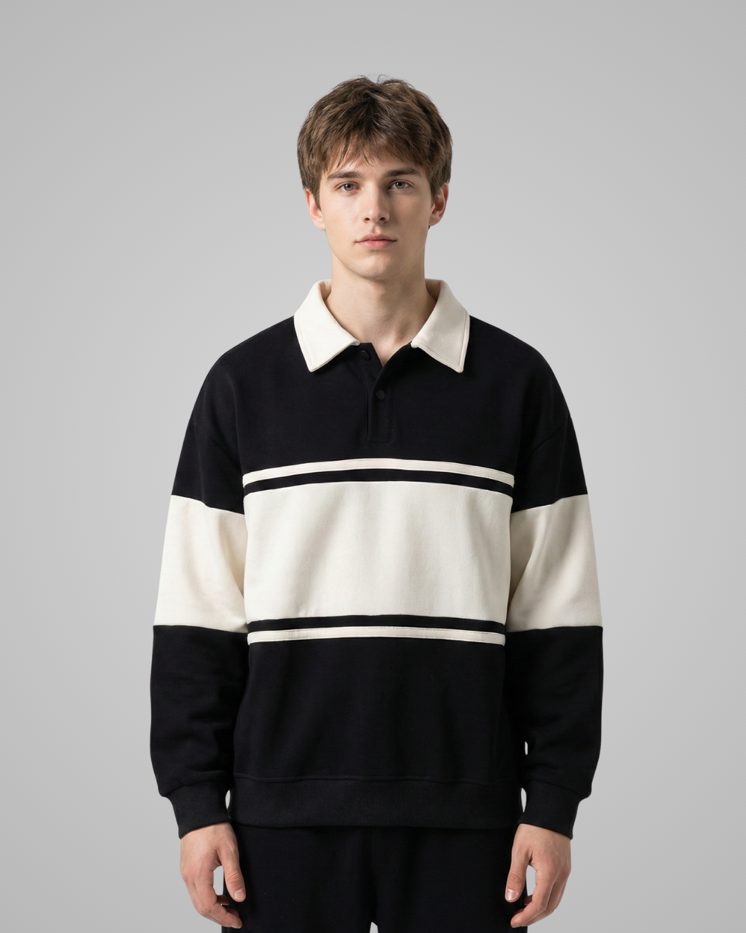 Man wearing a black and white striped sweater against a gray background