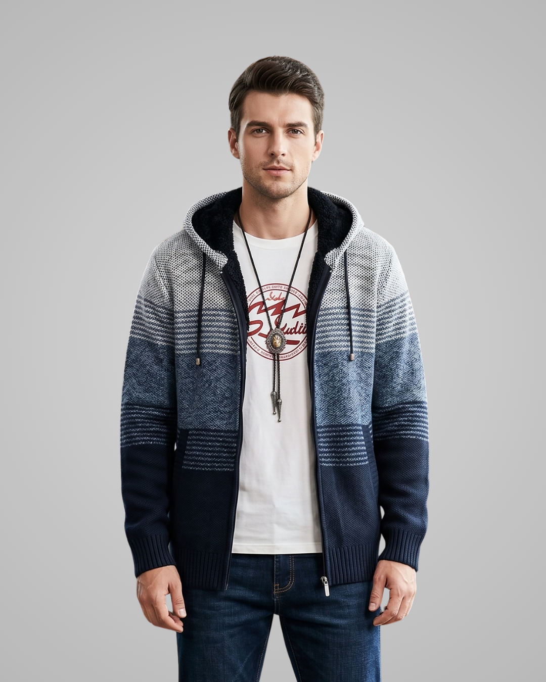 Man wearing a patterned hoodie over a white t-shirt with a graphic design on a gray background