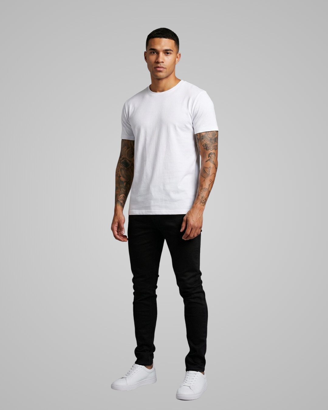 Man wearing a white t-shirt, black pants, and white sneakers on a gray background