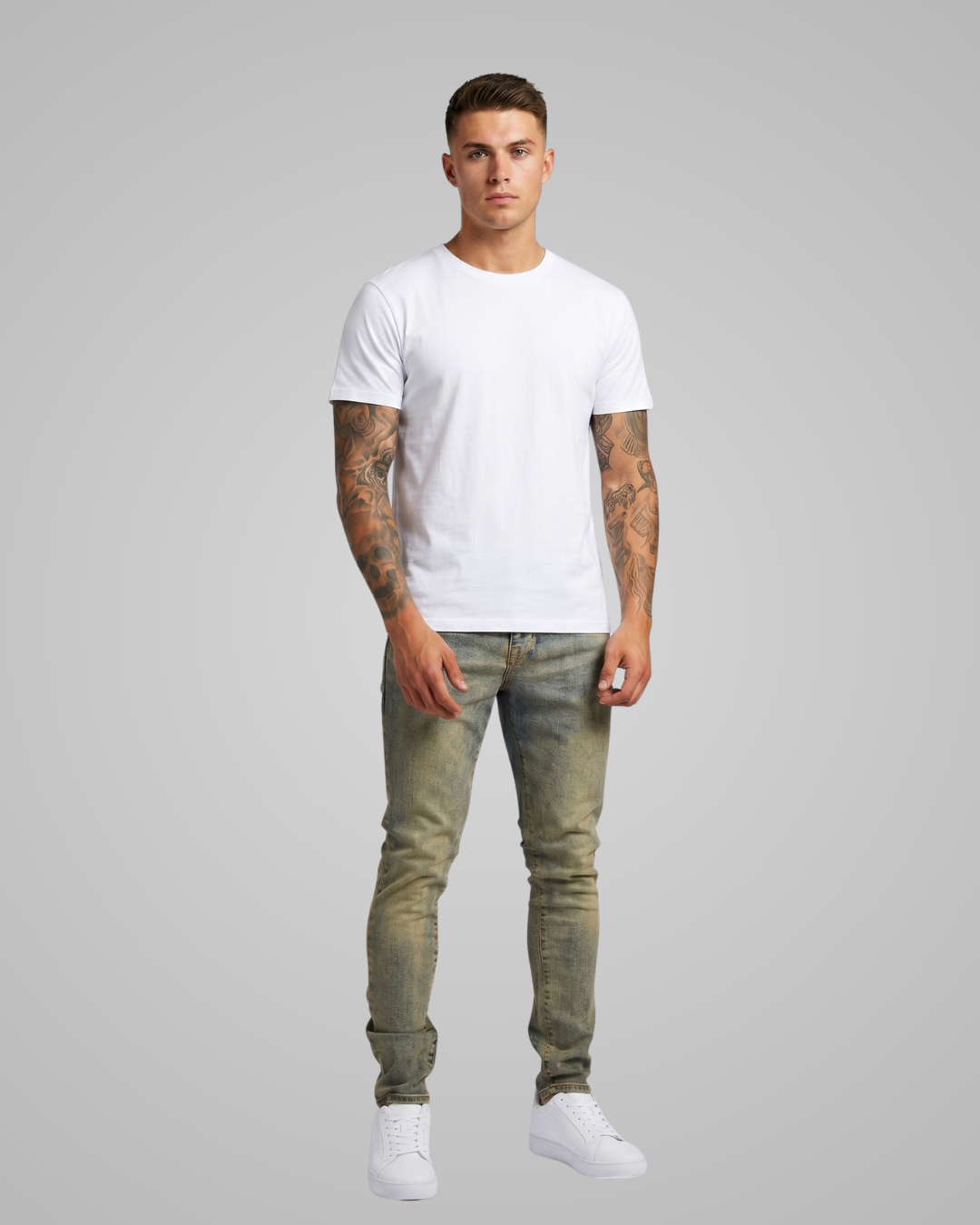 Man wearing a white t-shirt and green jeans on a gray background