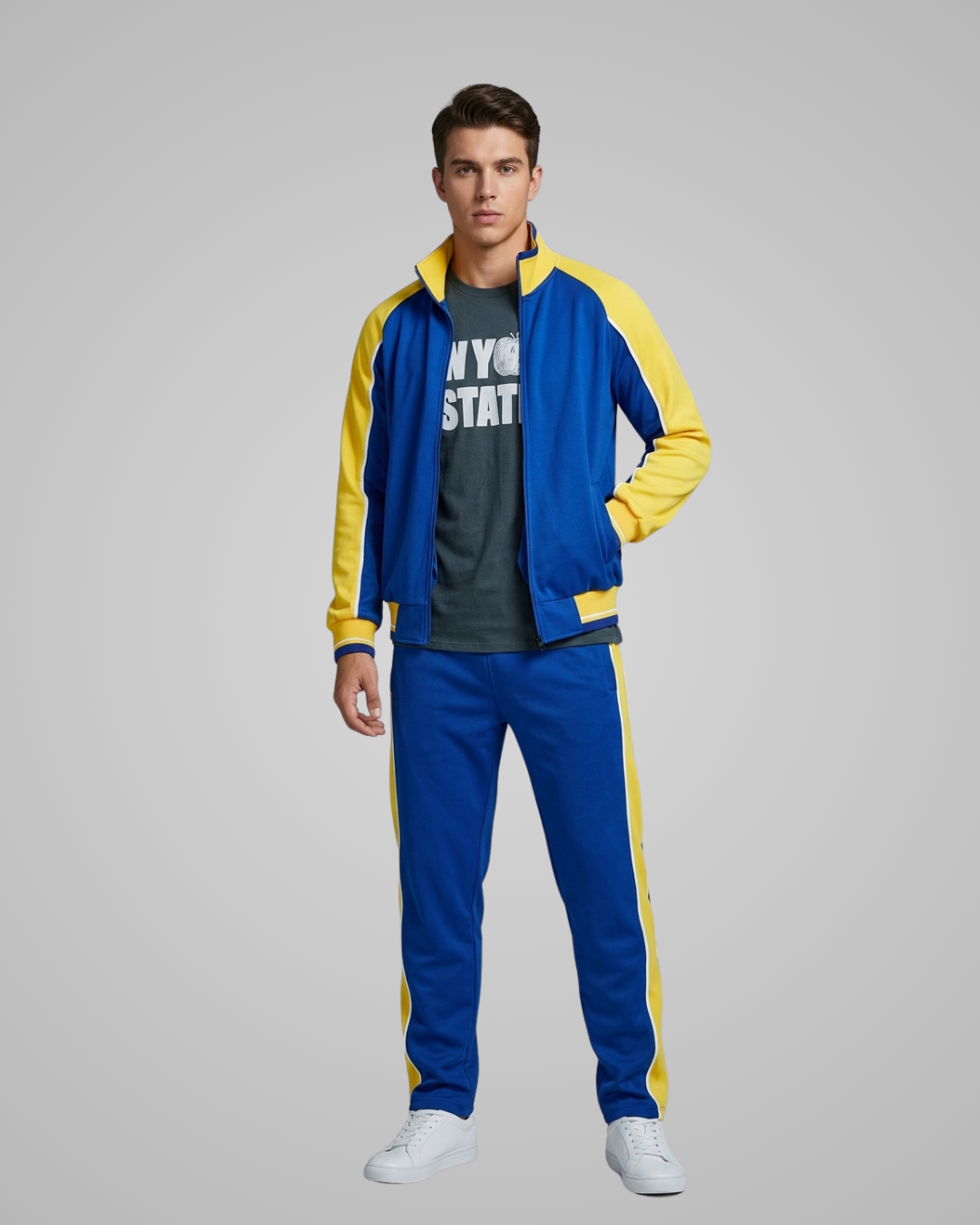 Man wearing a blue and yellow tracksuit on a gray background