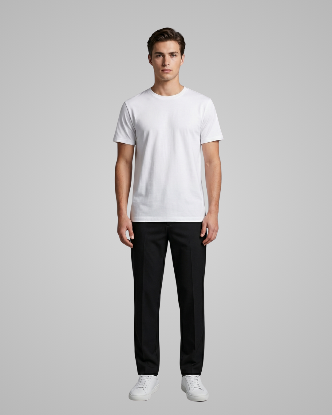 Man wearing a white t-shirt and black pants on a gray background