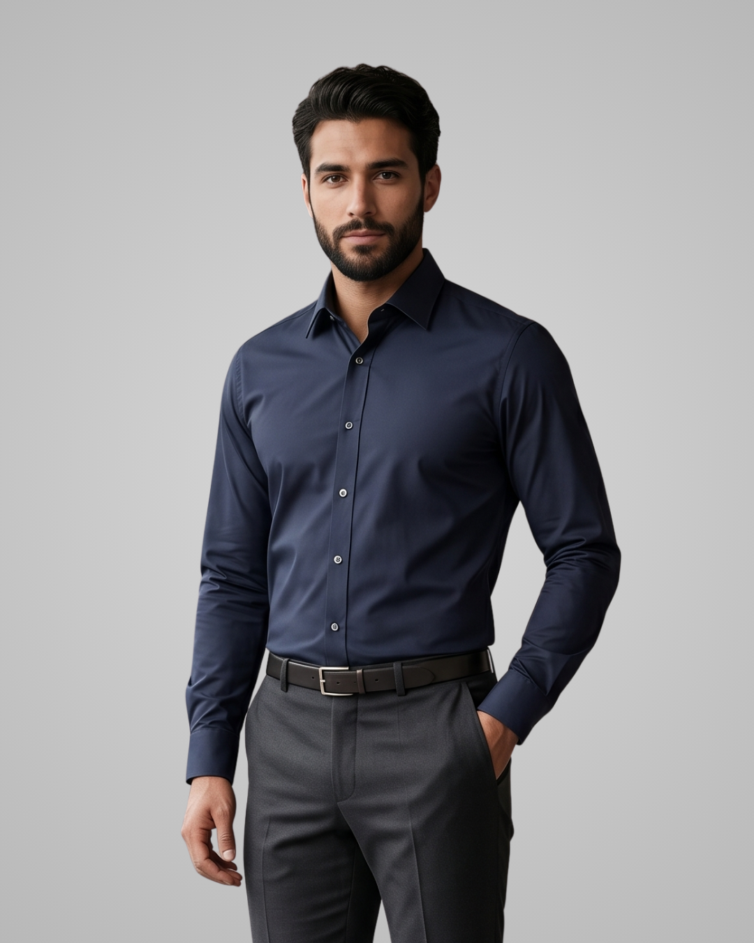 Man wearing a navy blue shirt and gray pants on a gray background