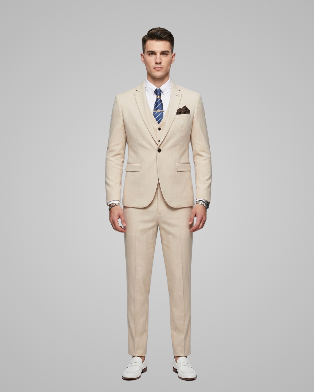 Man wearing a beige suit with a tie on a gray background
