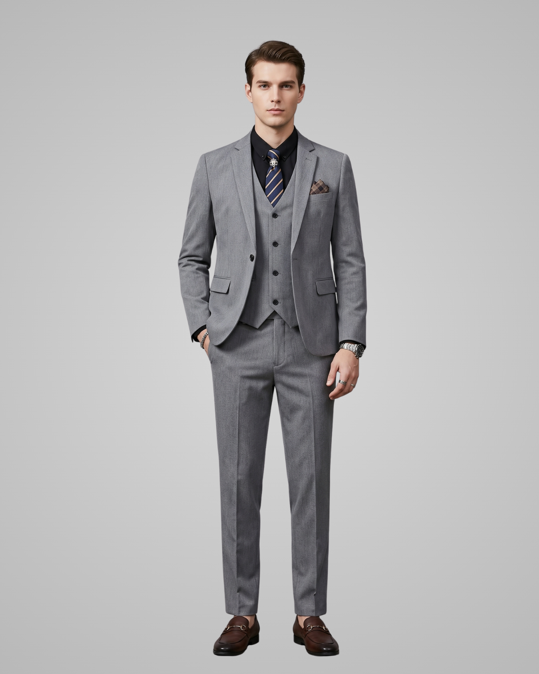 Man wearing a light grey suit with a tie on a gray background
