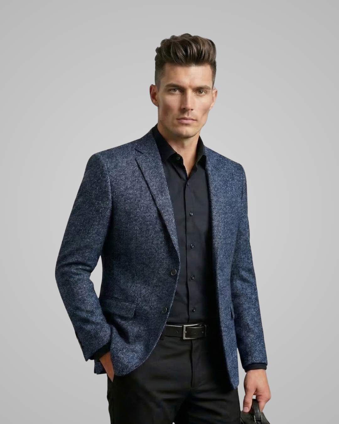 Man wearing a blue blazer over a black shirt on a gray background