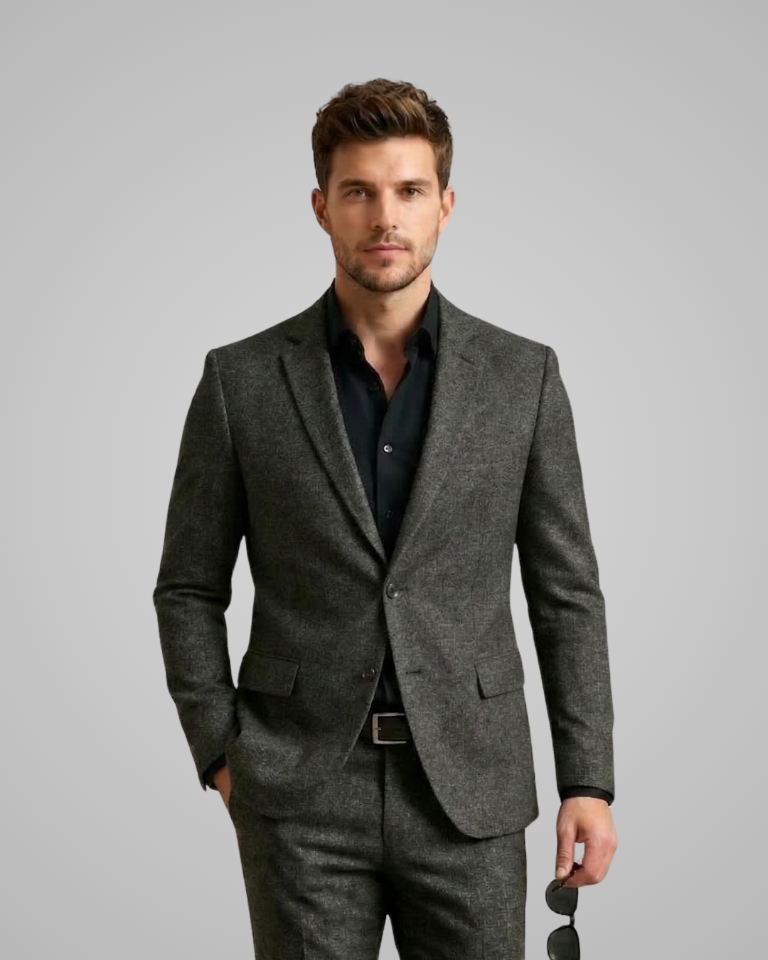 Man wearing a gray suit with a black shirt on a gray background