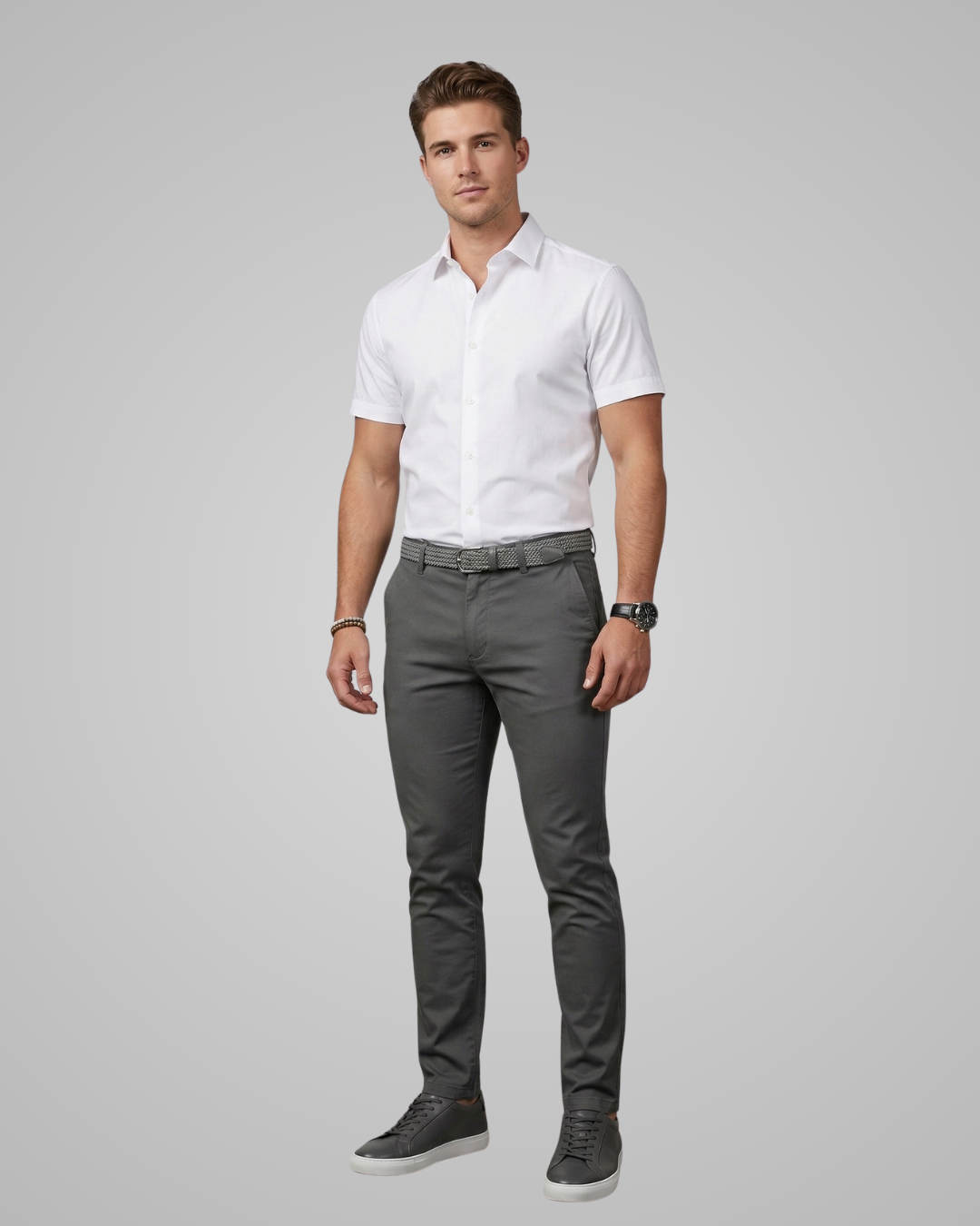 Man wearing a white shirt and gray pants on a gray background