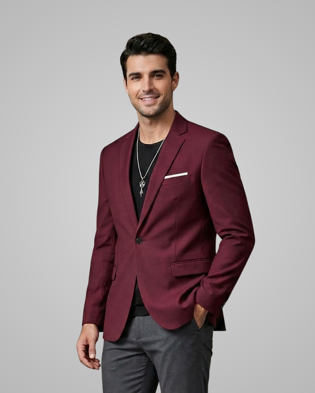 Man wearing a burgundy blazer over a black shirt on a gray background