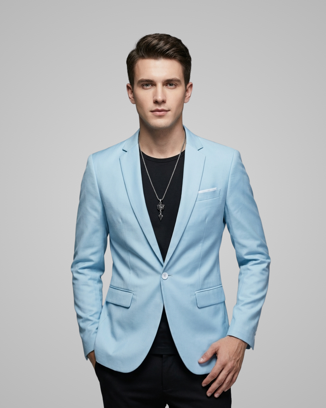 Man wearing a light blue blazer over a black shirt on a gray background