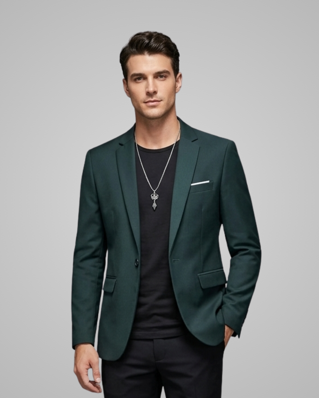 Man wearing a green blazer over a black shirt on a gray background