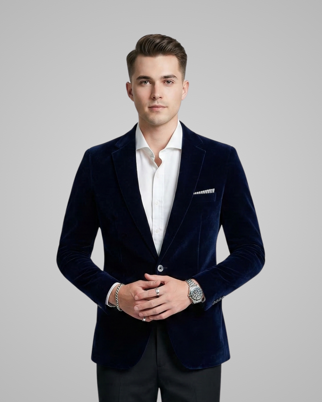 Man wearing a navy velvet blazer over a white shirt on a gray background