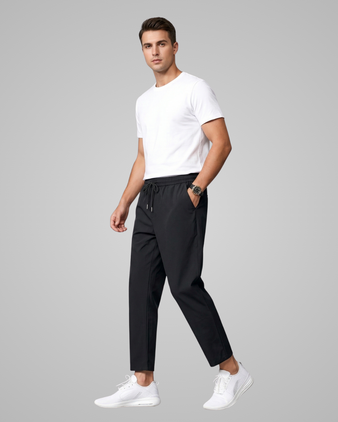 Man wearing a white t-shirt and black pants on a gray background