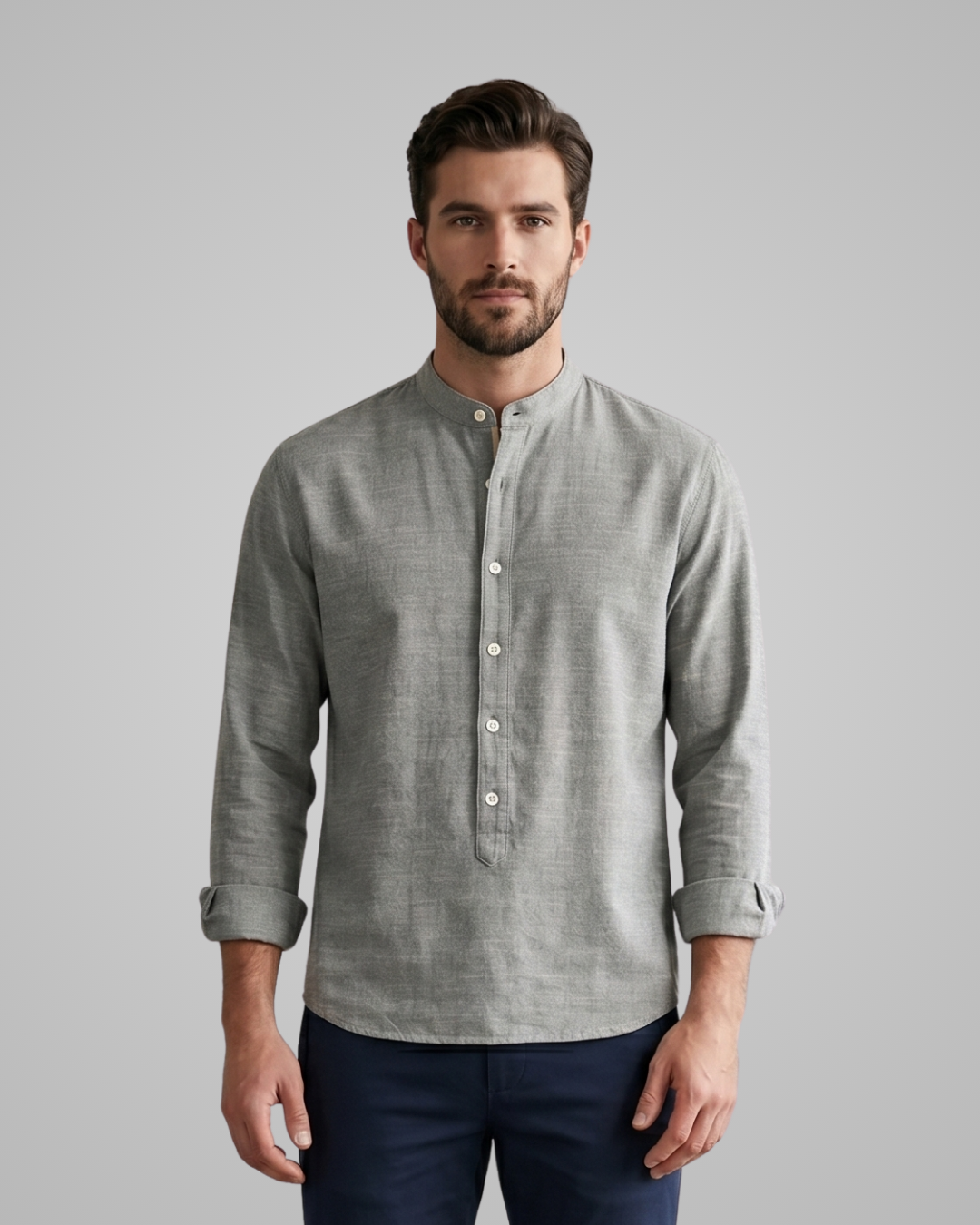 Man wearing a gray long-sleeve shirt with a collar on a gray background