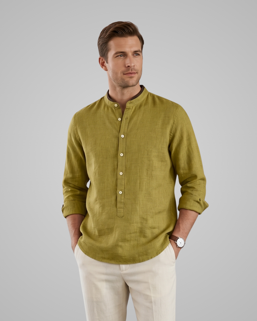Man wearing a green shirt and beige pants against a gray background