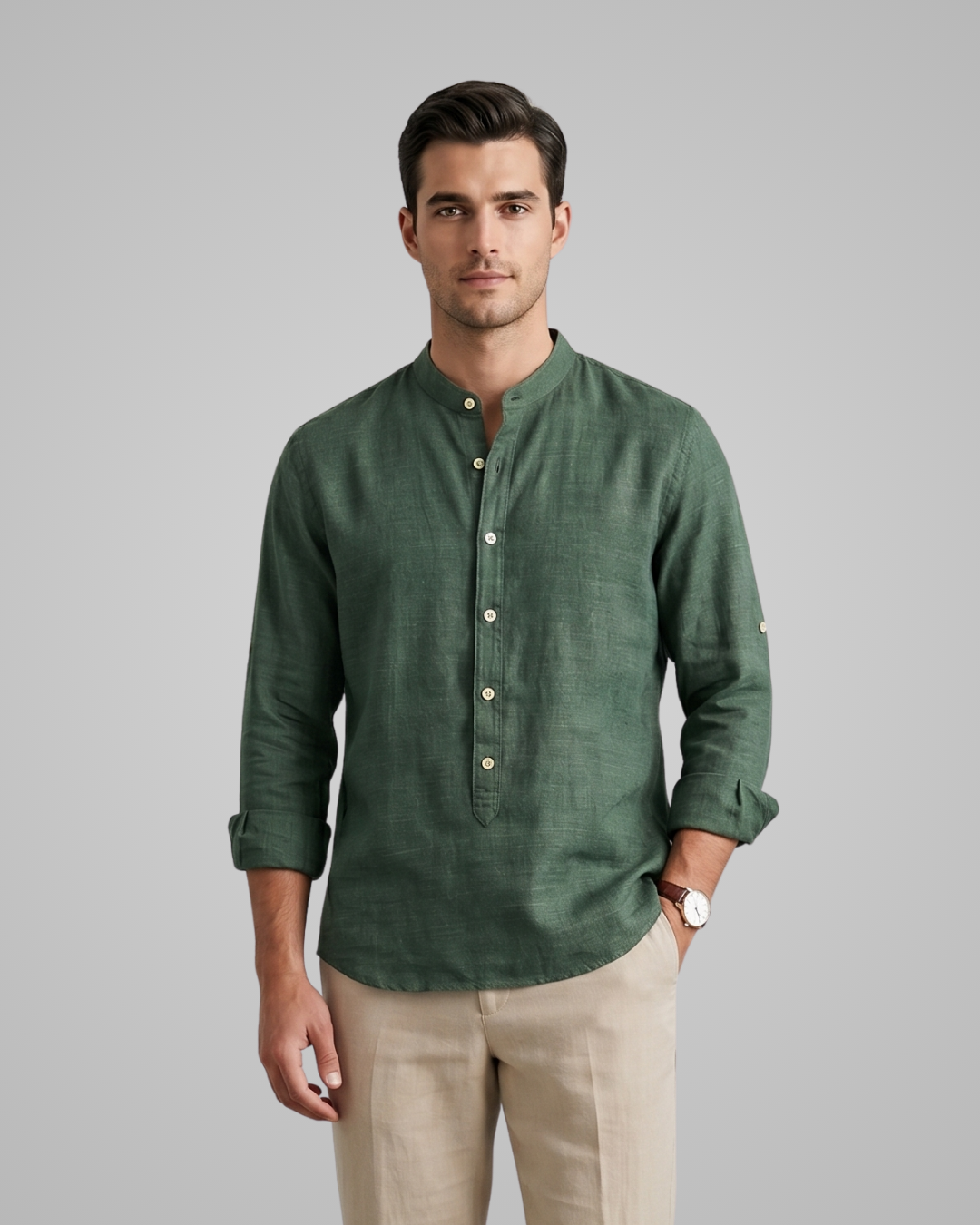 Man wearing a green shirt and beige pants on a gray background
