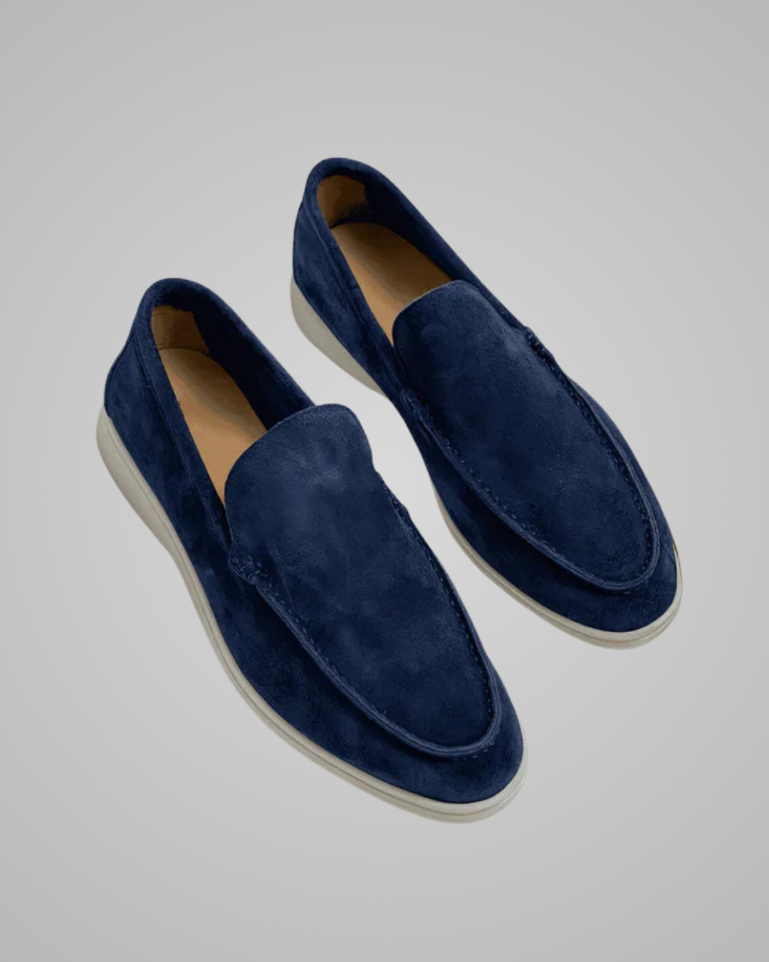 Pair of blue suede loafers on a light gray background