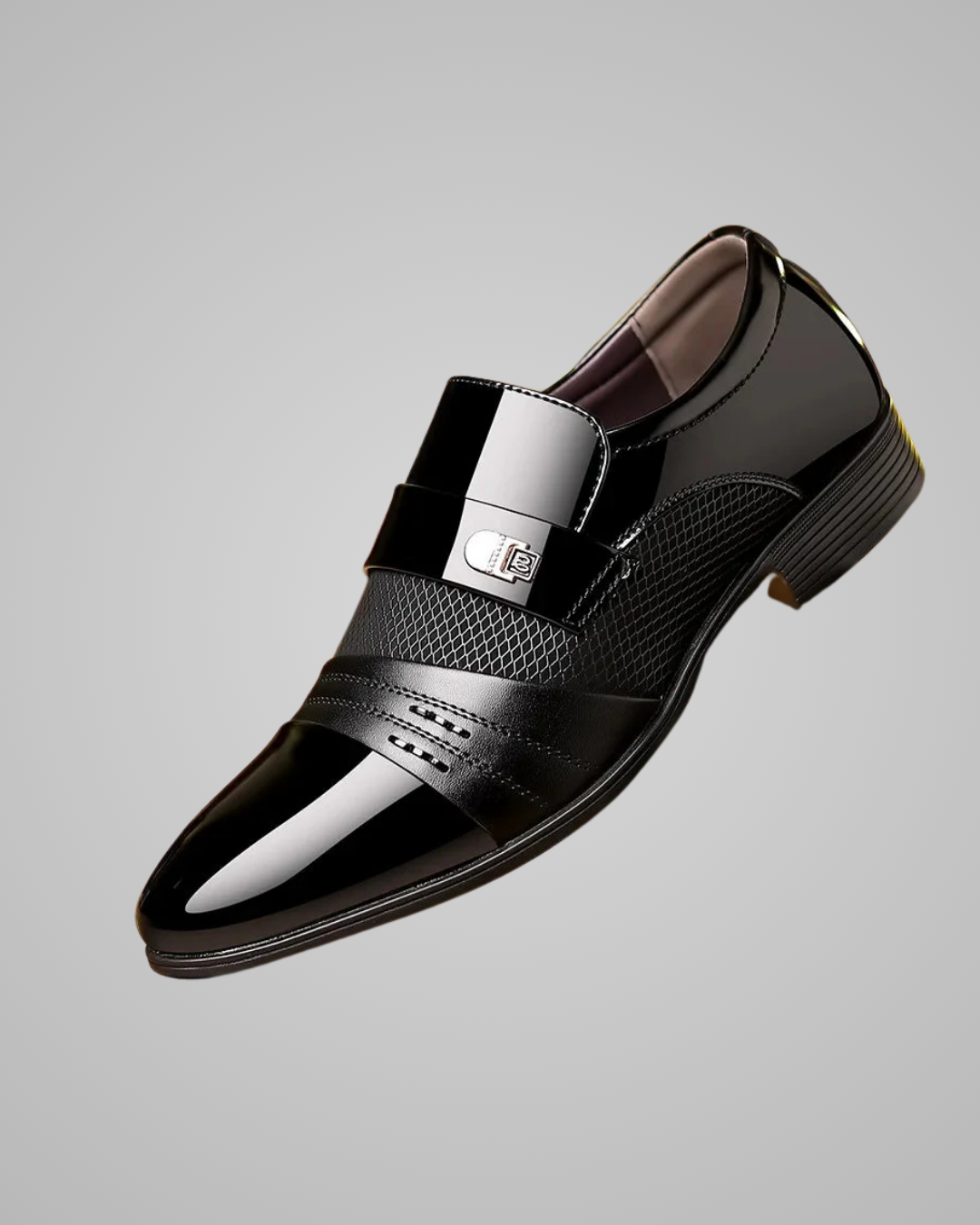 Black patent leather dress shoe with silver buckle on a gray background