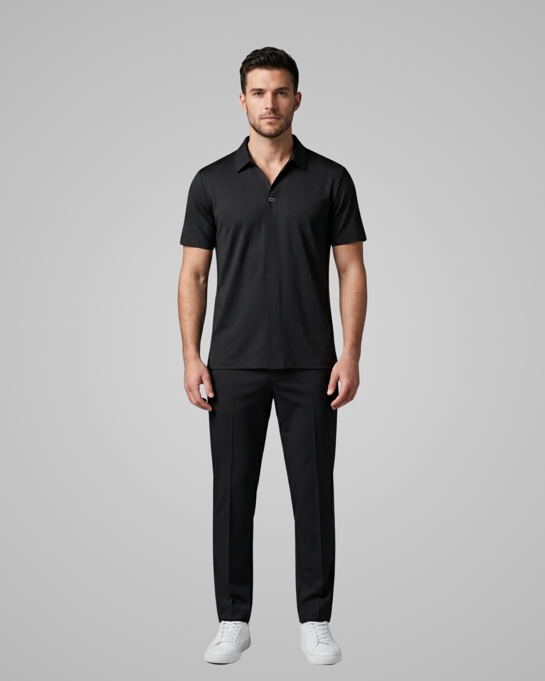 Man wearing a black polo shirt and pants on a gray background