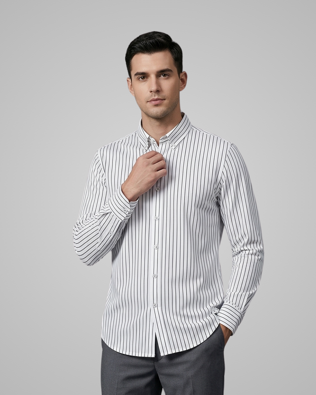 Man wearing a white shirt with black vertical stripes against a gray background