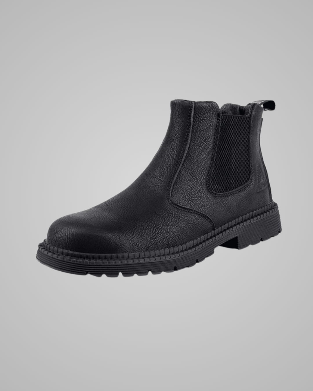 A single black leather Chelsea boot with a textured finish, elastic side panels, and a thick lug sole, shown against a neutral gray background.