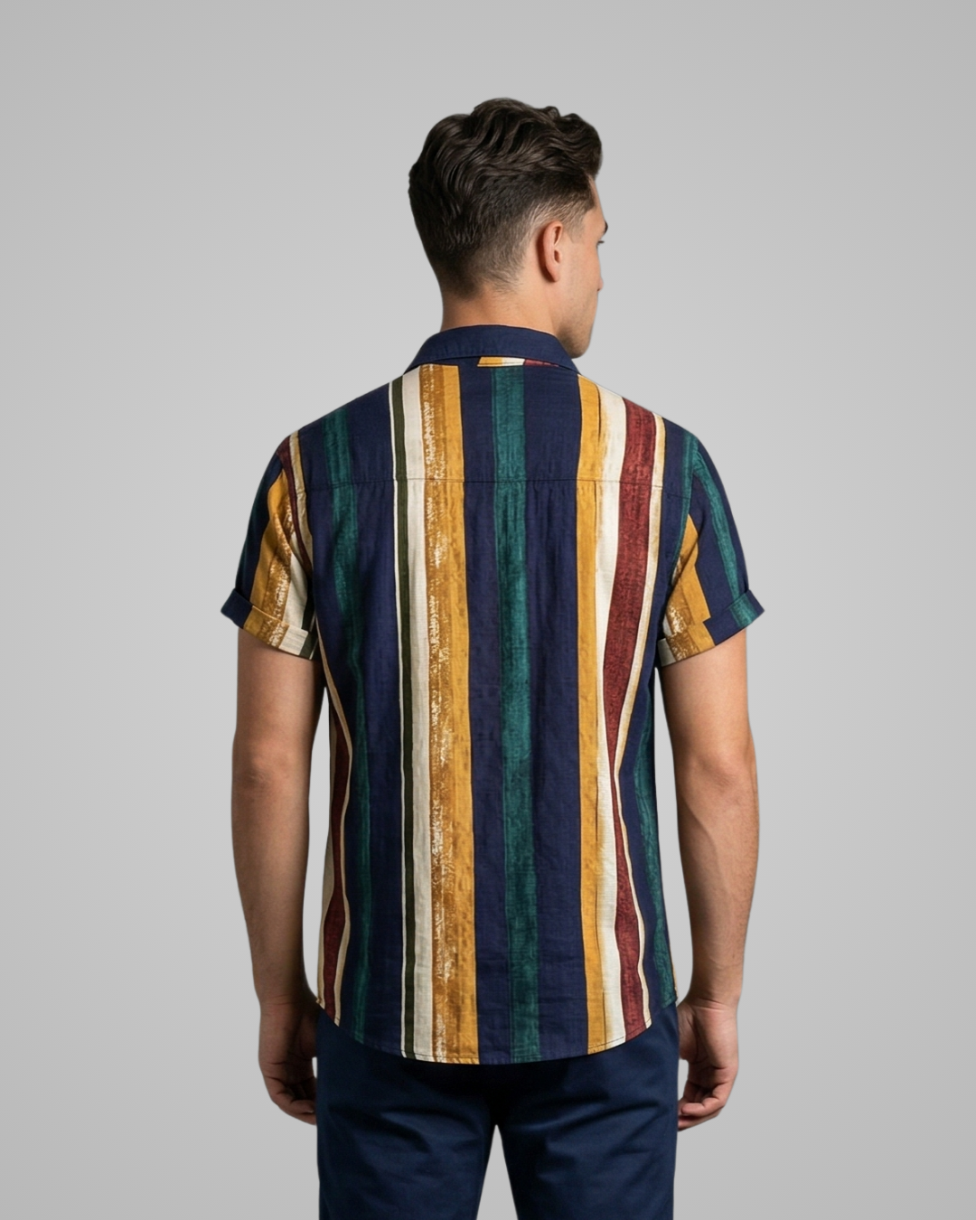 Man wearing a colorful striped shirt on a gray background