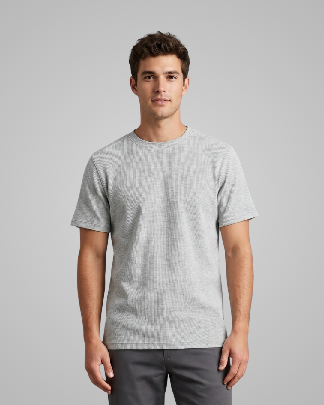 Man wearing a gray t-shirt against a plain background