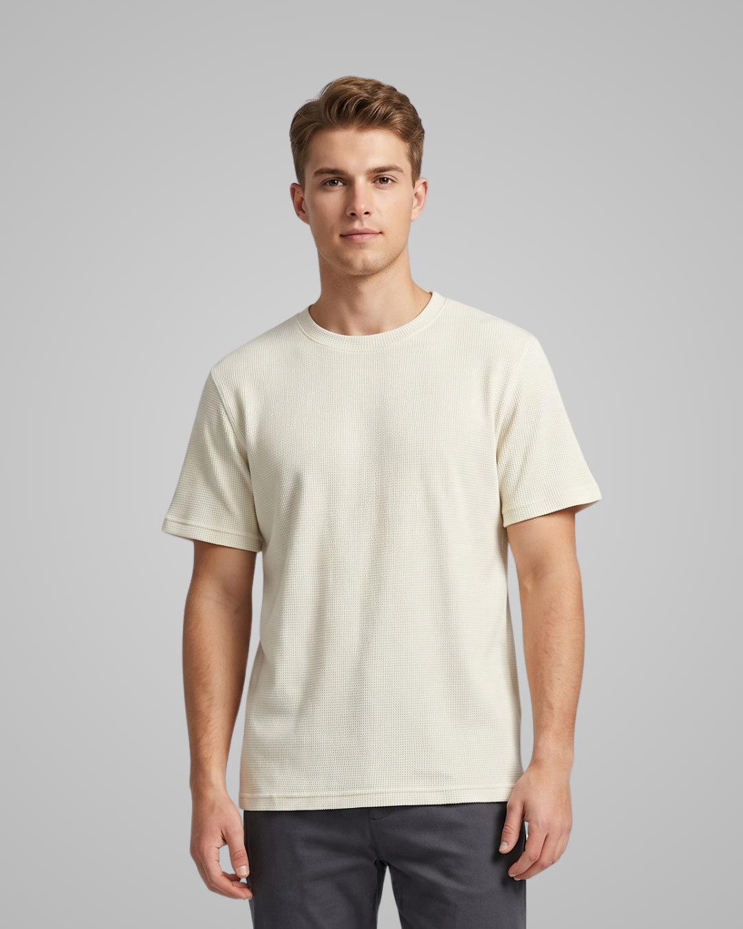 Man wearing a plain beige t-shirt against a gray background
