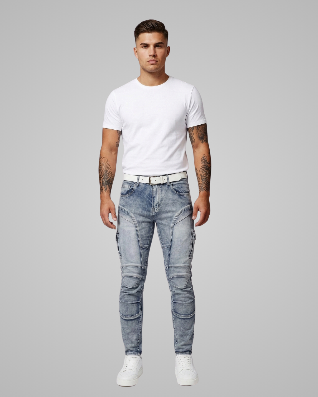 Man wearing a white t-shirt and light blue jeans on a gray background