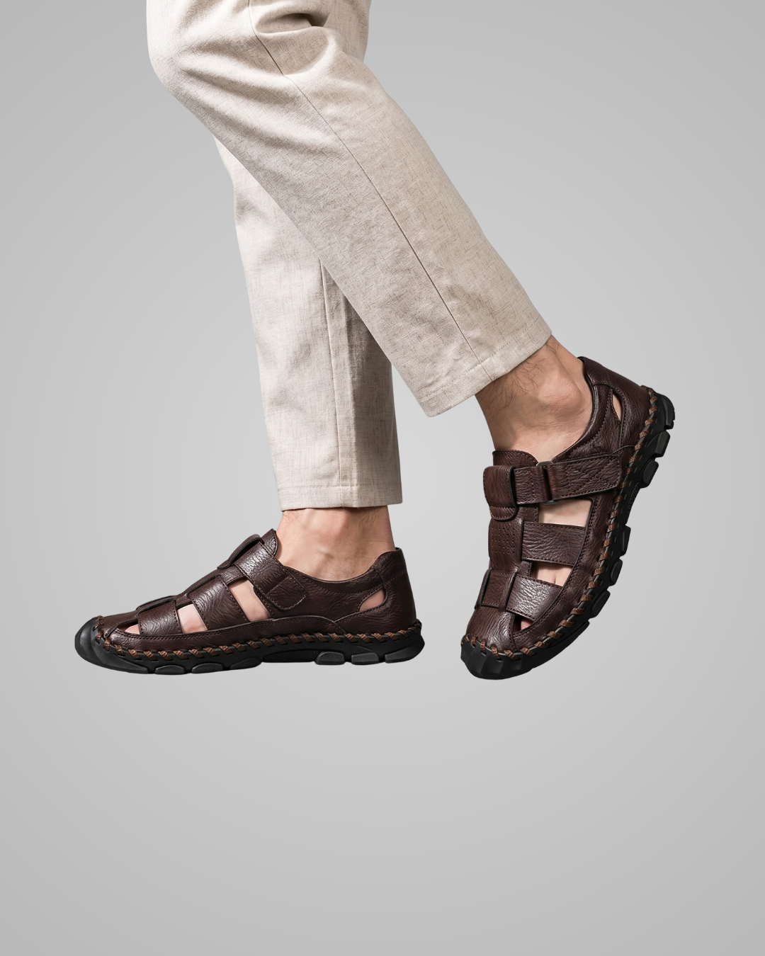 Brown sandals worn with beige pants on a gray background