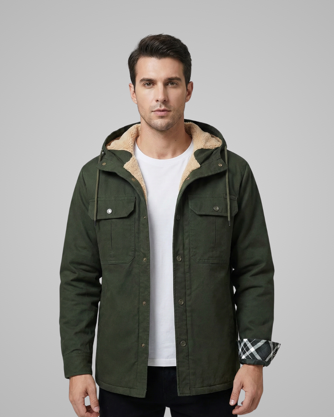 Man wearing a green jacket with a hood on a gray background