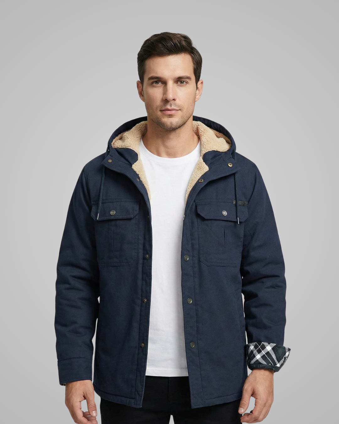 Man wearing a navy blue jacket with a beige hood on a gray background